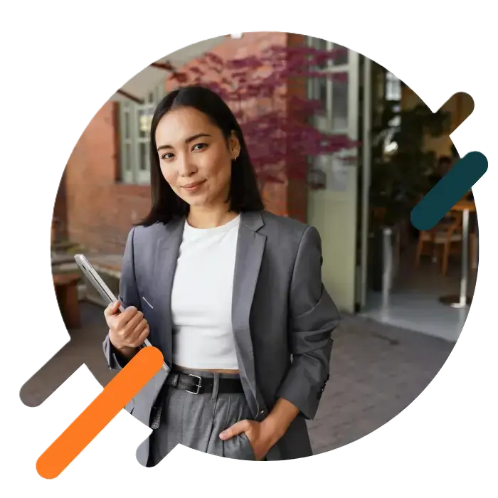 Asian businesswoman outside an office holding a laptop